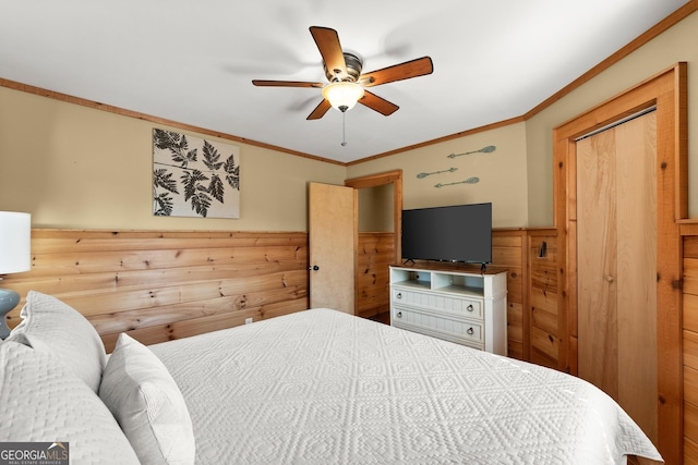 bedroom with wood walls, ceiling fan, ornamental molding, and wainscoting