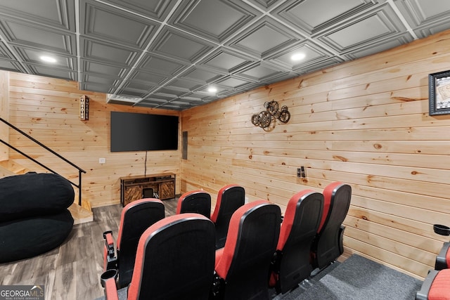 cinema room with wood walls, wood finished floors, and an ornate ceiling