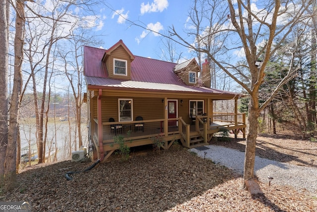 view of front of house with metal roof, a porch, and ac unit