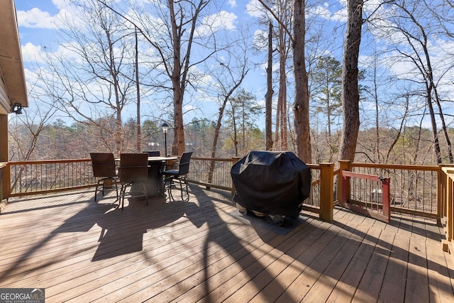 deck with outdoor dining area and a grill