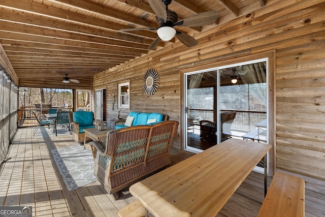 wooden deck featuring an outdoor living space, a ceiling fan, and outdoor dining space