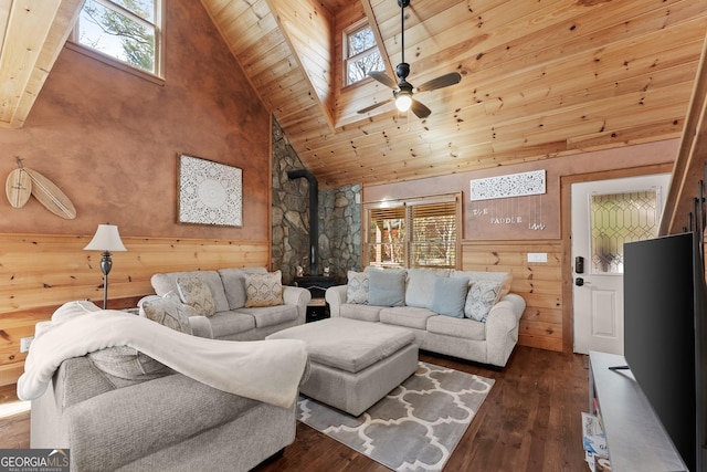 living room with high vaulted ceiling, wood ceiling, a ceiling fan, dark wood finished floors, and a wood stove