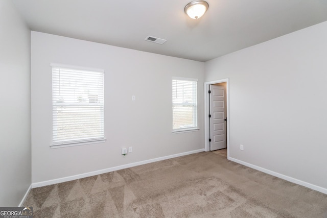 unfurnished room featuring light carpet, visible vents, and baseboards