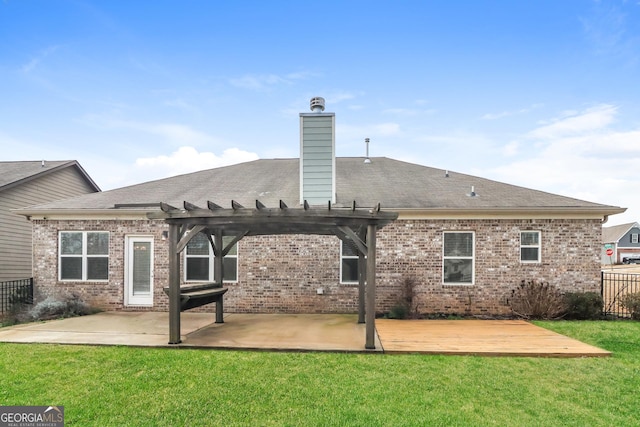 rear view of property with a chimney, a deck, a yard, a patio area, and brick siding