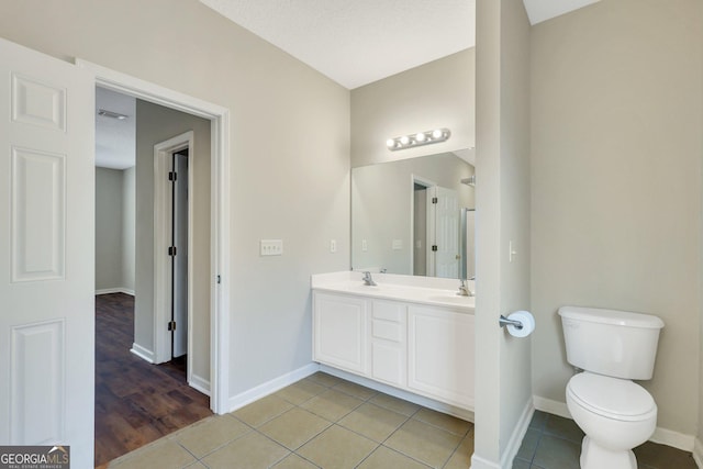 full bathroom featuring tile patterned flooring, a sink, toilet, and double vanity