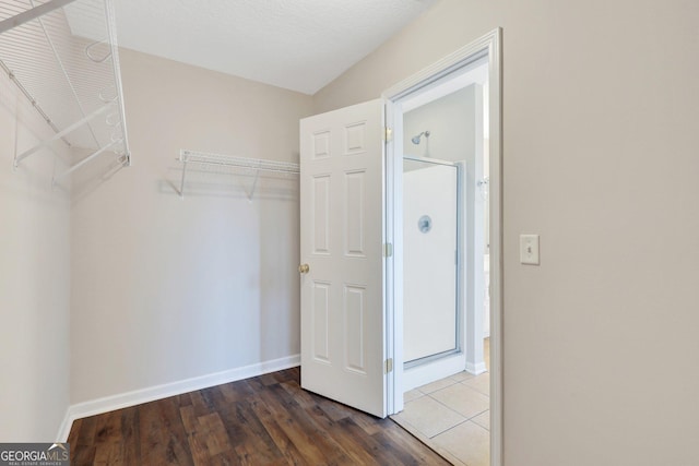 spacious closet with dark wood-type flooring