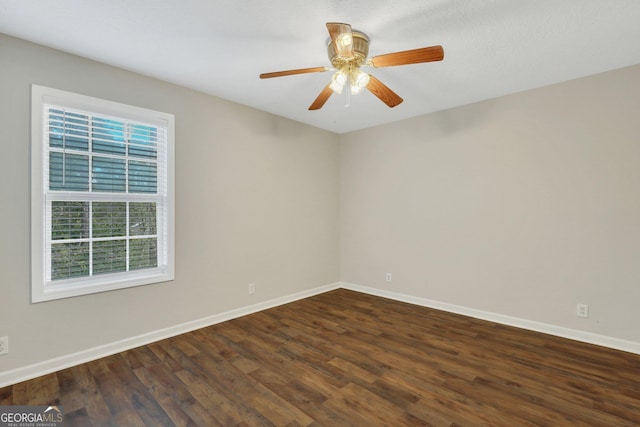 unfurnished room with dark wood-style floors, baseboards, and a ceiling fan