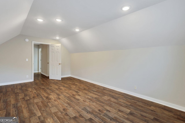 additional living space featuring lofted ceiling, baseboards, dark wood-type flooring, and recessed lighting