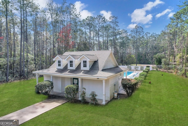 view of front of home featuring fence, a fenced in pool, and a front yard