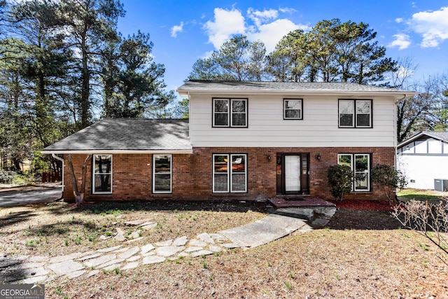 view of front facade featuring brick siding, central AC, and roof with shingles