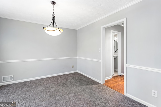 spare room with carpet, visible vents, crown molding, and baseboards