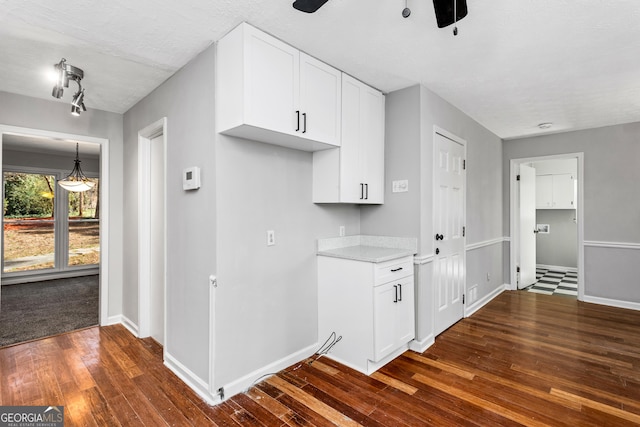 kitchen featuring white cabinetry, dark wood finished floors, and baseboards