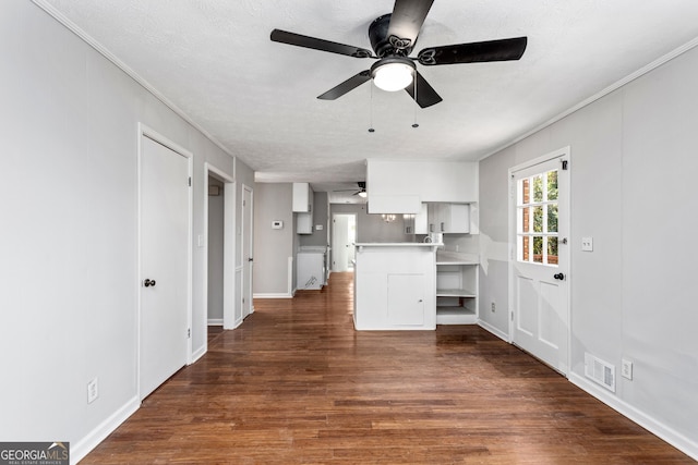 kitchen with dark wood-style flooring, light countertops, visible vents, white cabinets, and a textured ceiling