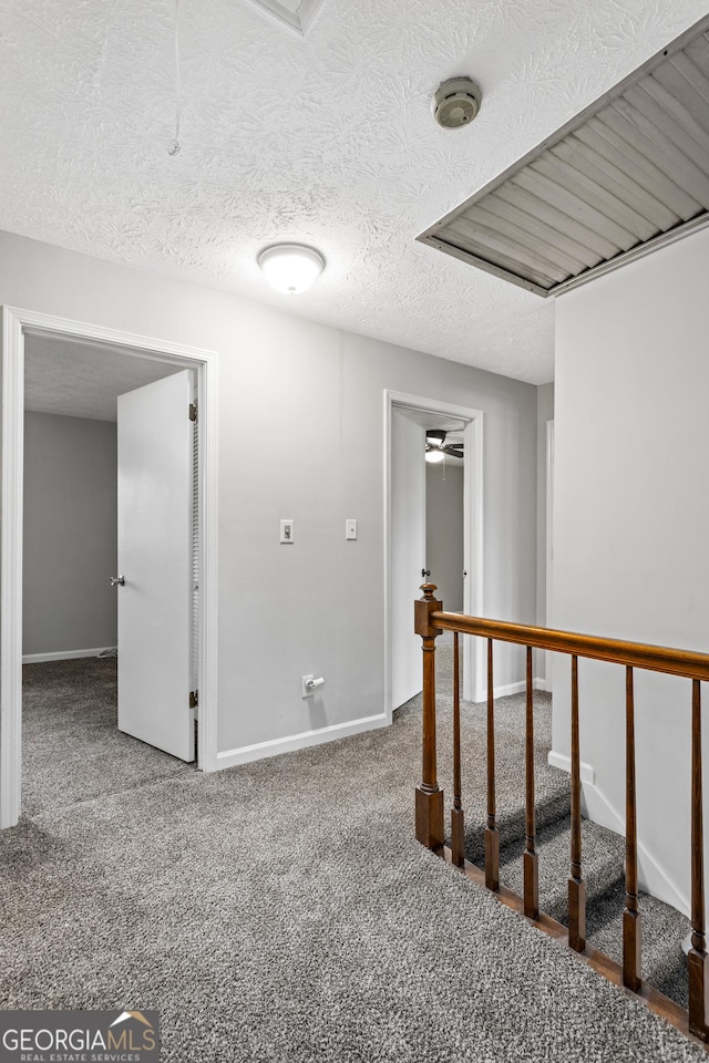 carpeted spare room featuring baseboards and a textured ceiling