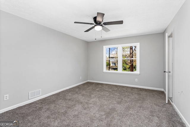 carpeted spare room featuring visible vents, baseboards, and a ceiling fan