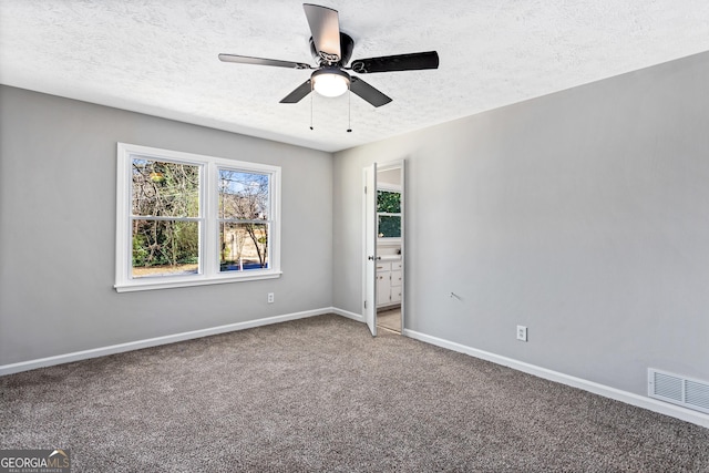 spare room with visible vents, a ceiling fan, carpet flooring, a textured ceiling, and baseboards