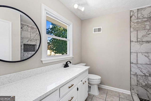 full bathroom featuring visible vents, toilet, vanity, a textured ceiling, and baseboards