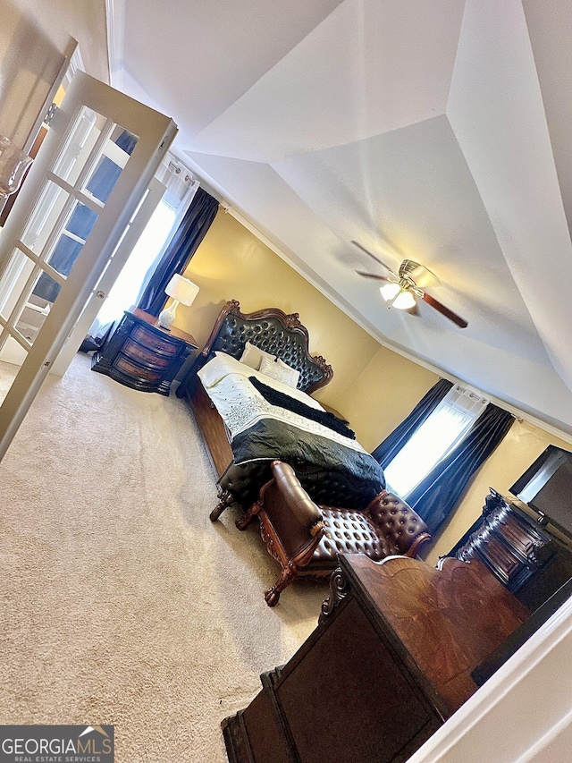 carpeted bedroom featuring lofted ceiling and ceiling fan