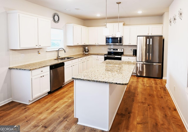 kitchen featuring stainless steel appliances, a kitchen island, and white cabinetry