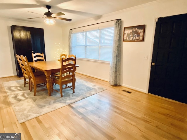 dining room featuring a ceiling fan, light wood-type flooring, visible vents, and baseboards