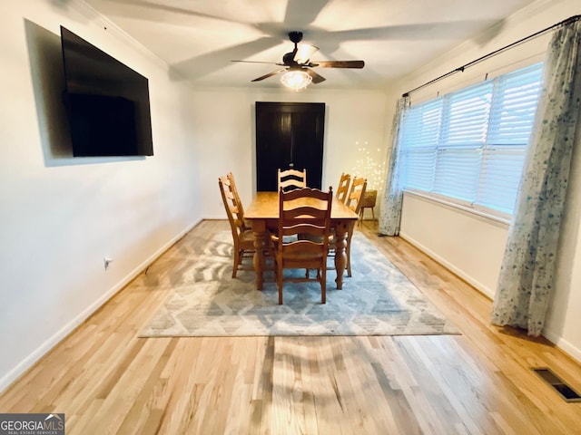 dining space featuring a ceiling fan, wood finished floors, visible vents, and baseboards