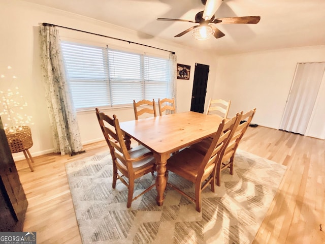 dining room with a ceiling fan, light wood-type flooring, ornamental molding, and baseboards