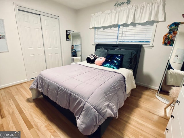 bedroom featuring a closet, baseboards, and light wood finished floors