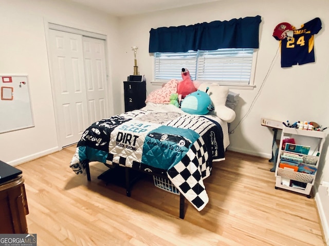 bedroom featuring a closet, baseboards, and wood finished floors