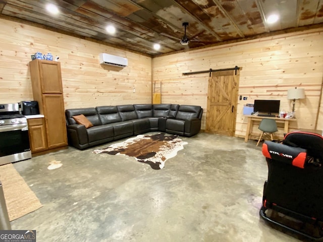 living area with a wall mounted air conditioner, unfinished concrete flooring, wood walls, and a barn door