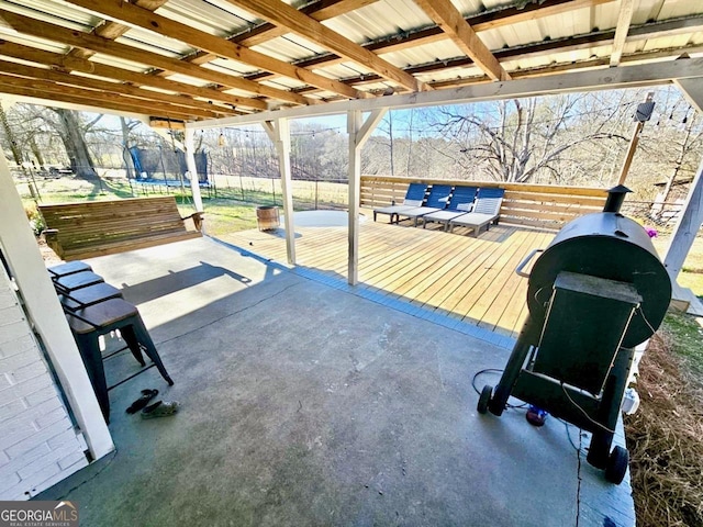 view of patio / terrace featuring a trampoline, fence, and a deck