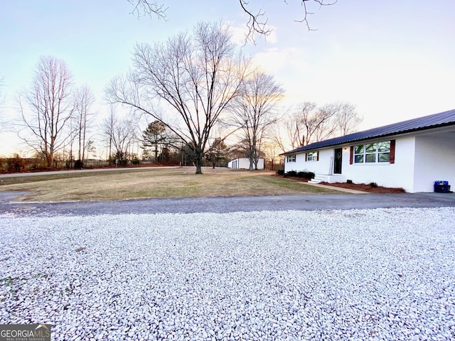 yard at dusk featuring a storage unit