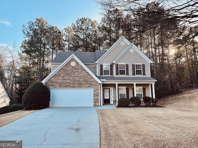 traditional-style house featuring covered porch, stone siding, and driveway