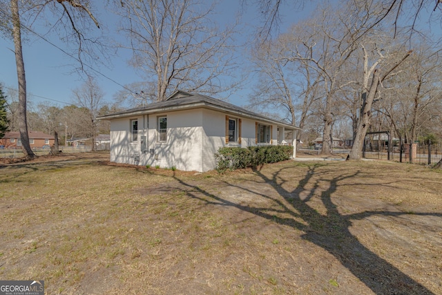 view of side of property with a yard, fence, and stucco siding