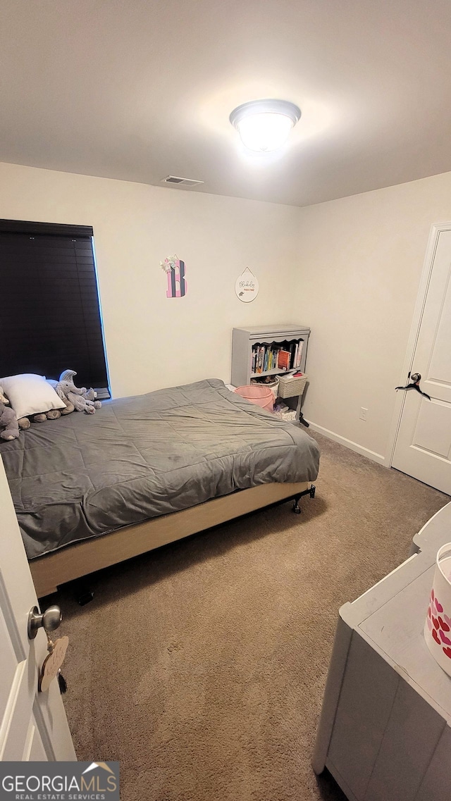 carpeted bedroom featuring visible vents and baseboards