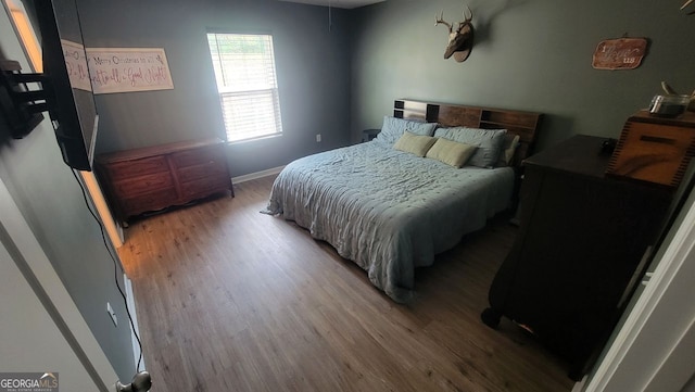 bedroom featuring baseboards and wood finished floors