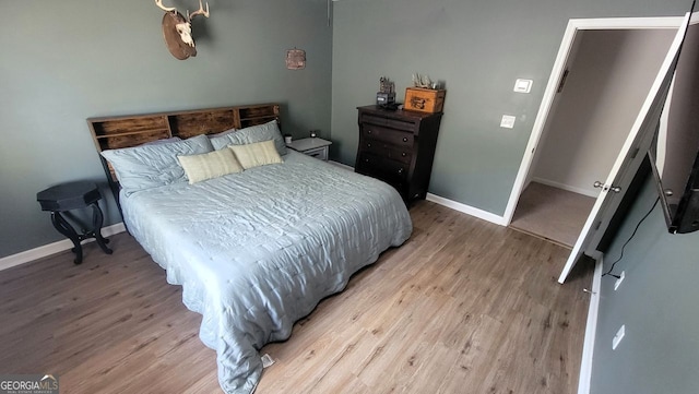 bedroom featuring light wood-style flooring and baseboards