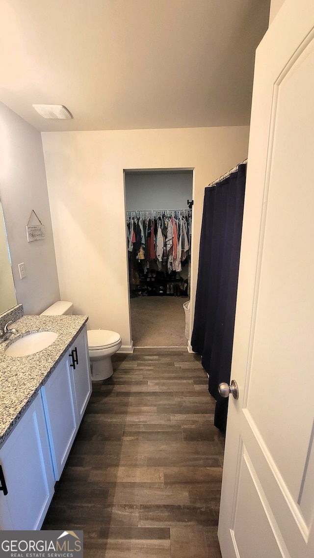 full bathroom featuring toilet, wood finished floors, and vanity