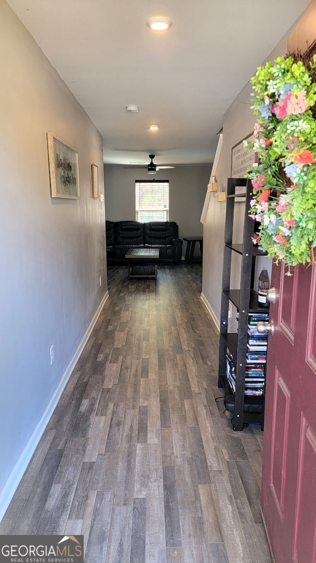 hall with dark wood-style floors and baseboards