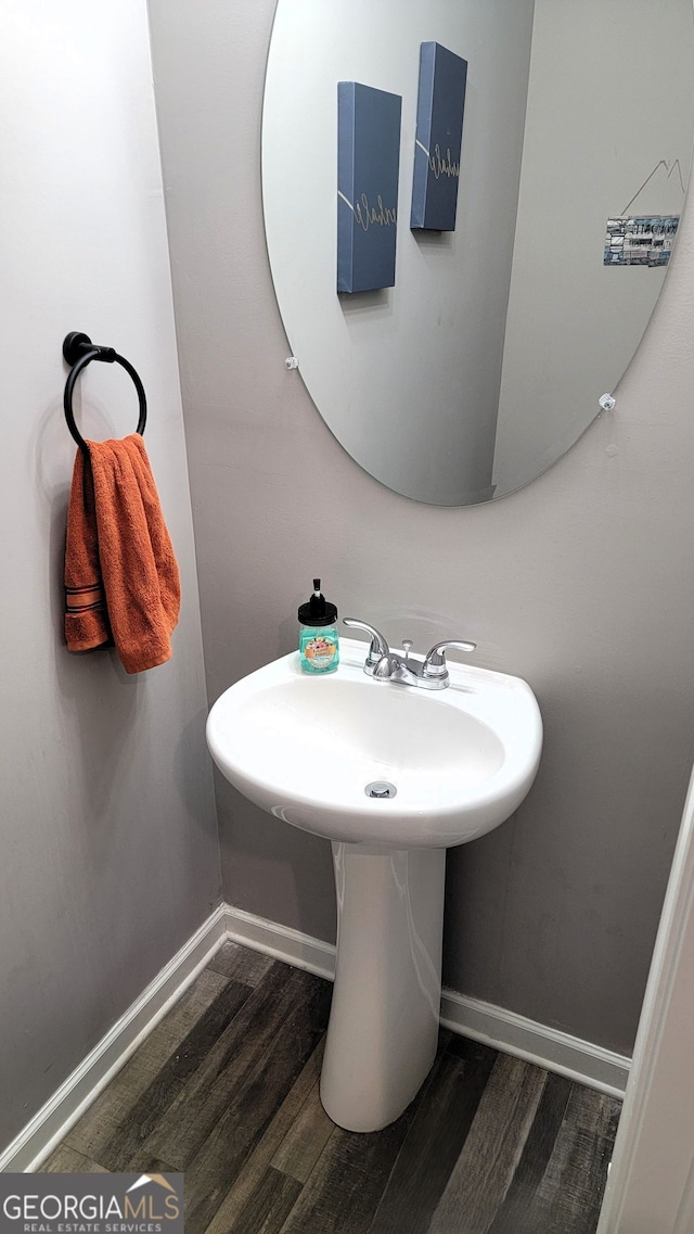 bathroom with baseboards and wood finished floors