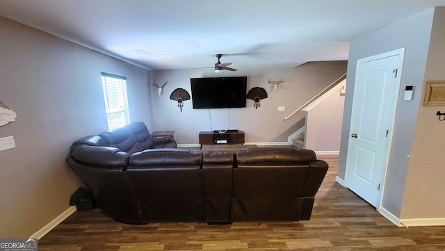 living area featuring a ceiling fan, stairway, baseboards, and wood finished floors