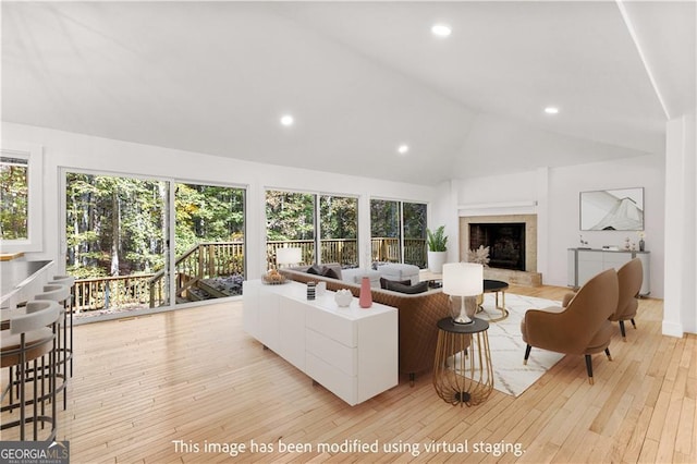 living room with lofted ceiling, light wood-style flooring, a fireplace, and recessed lighting