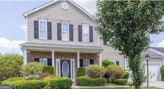 view of front facade featuring brick siding, driveway, and an attached garage