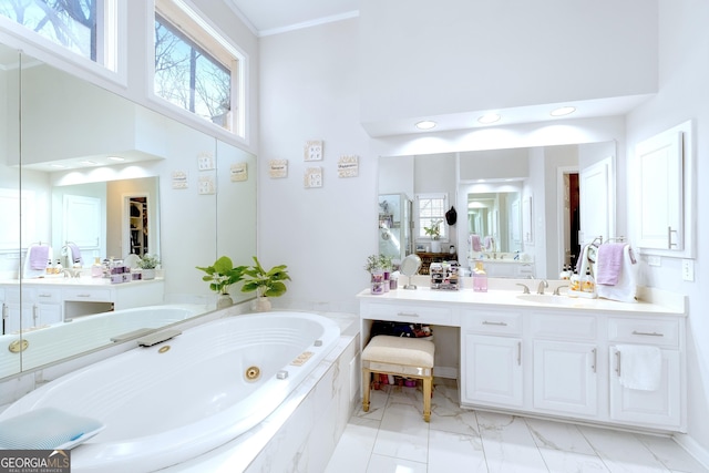 bathroom with a jetted tub, crown molding, vanity, and a towering ceiling