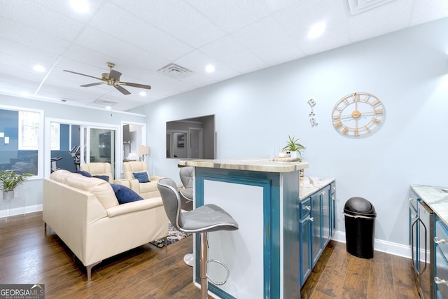 living room featuring a ceiling fan, dark wood-style flooring, visible vents, and baseboards