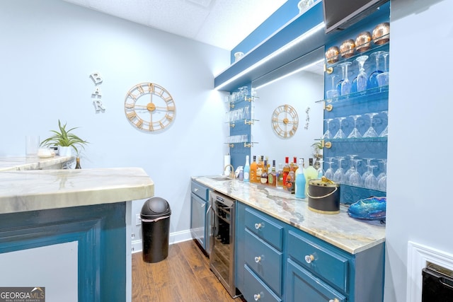 bar with a dry bar, beverage cooler, baseboards, dark wood finished floors, and a sink