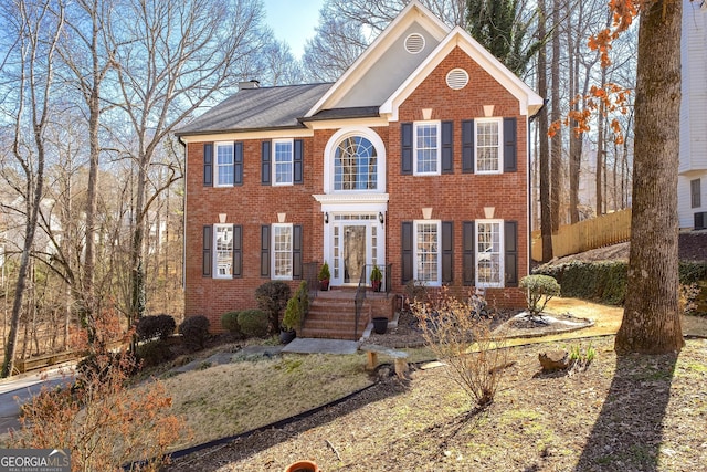 view of front of home with brick siding and a chimney