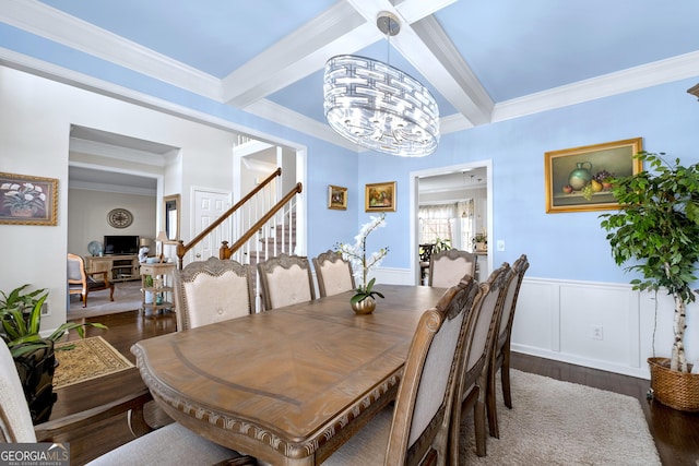 dining area with a notable chandelier, dark wood-style flooring, beamed ceiling, and wainscoting