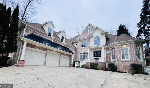 traditional home with a garage, concrete driveway, and brick siding