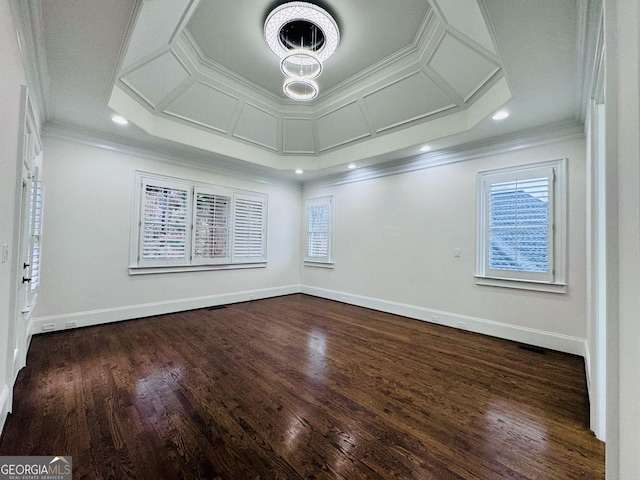 empty room with a wealth of natural light, dark wood-style floors, baseboards, and crown molding