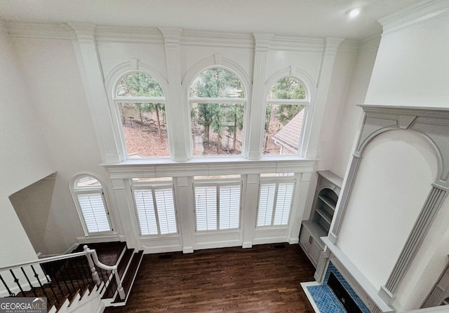 interior space featuring ornamental molding and dark wood-type flooring